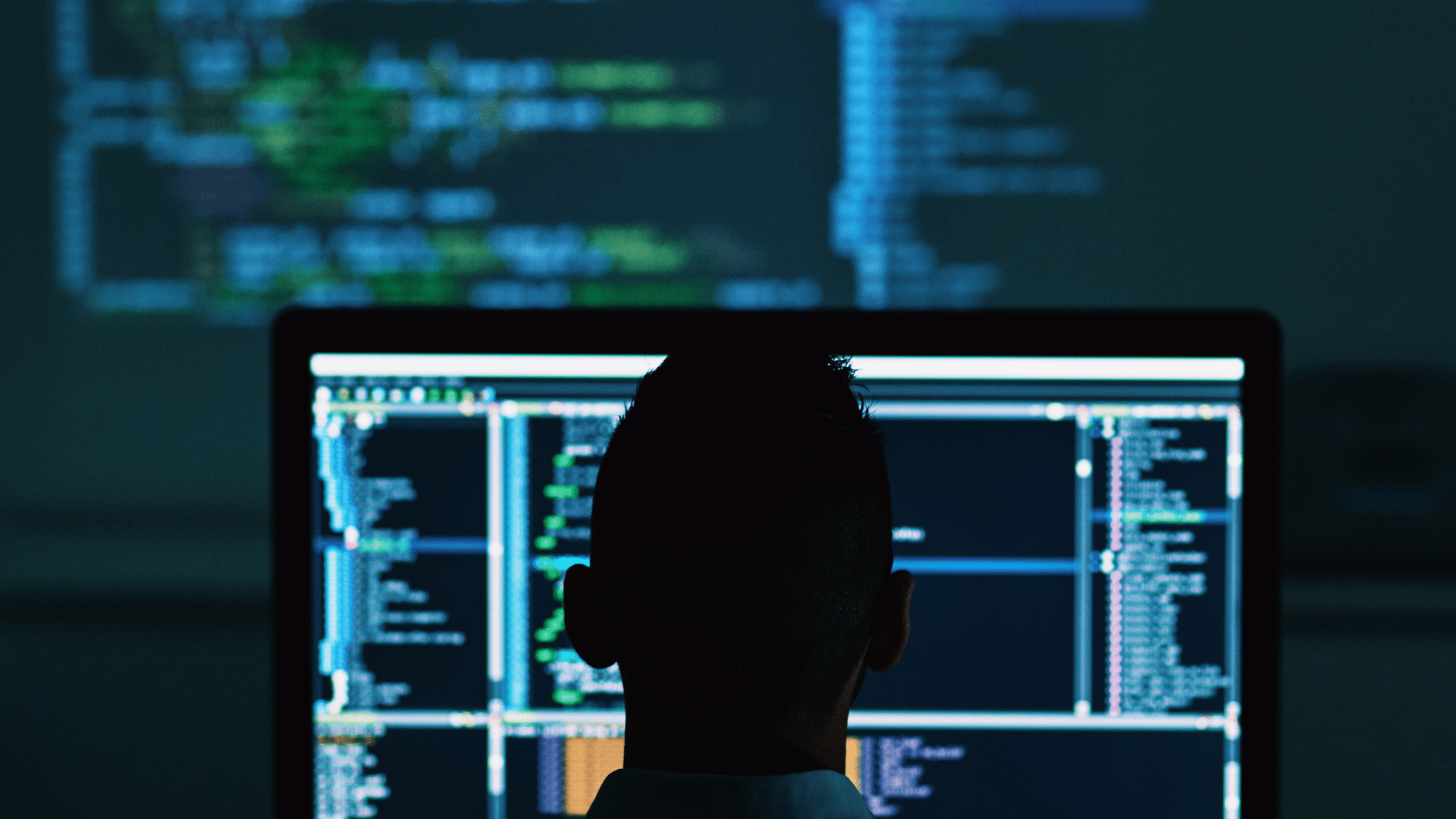 A man sat infront of his computer coding a high security site on his computer